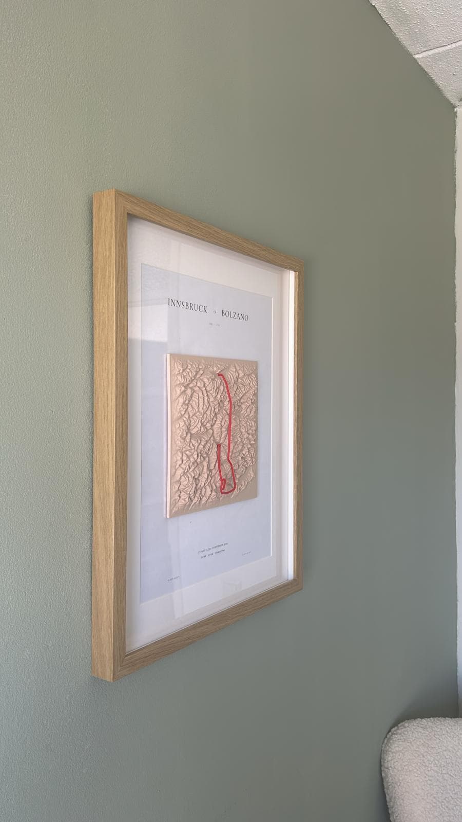 The framed piece hung on a wall at a three-quarter angle, showing its scale next to the room.